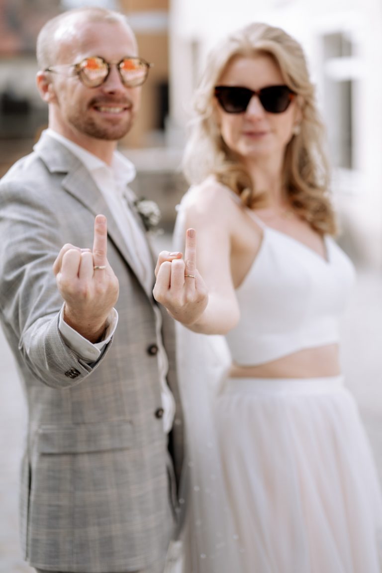 Hochzeitspaar in moderner Altstadt, Schwabach, hält Ringe in die Kamera.