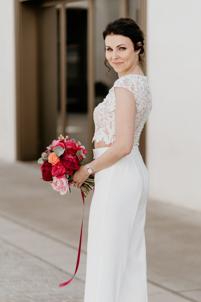 Braut in modernem Zweiteiler steht stilvoll in der Nürnberger Innenstand.